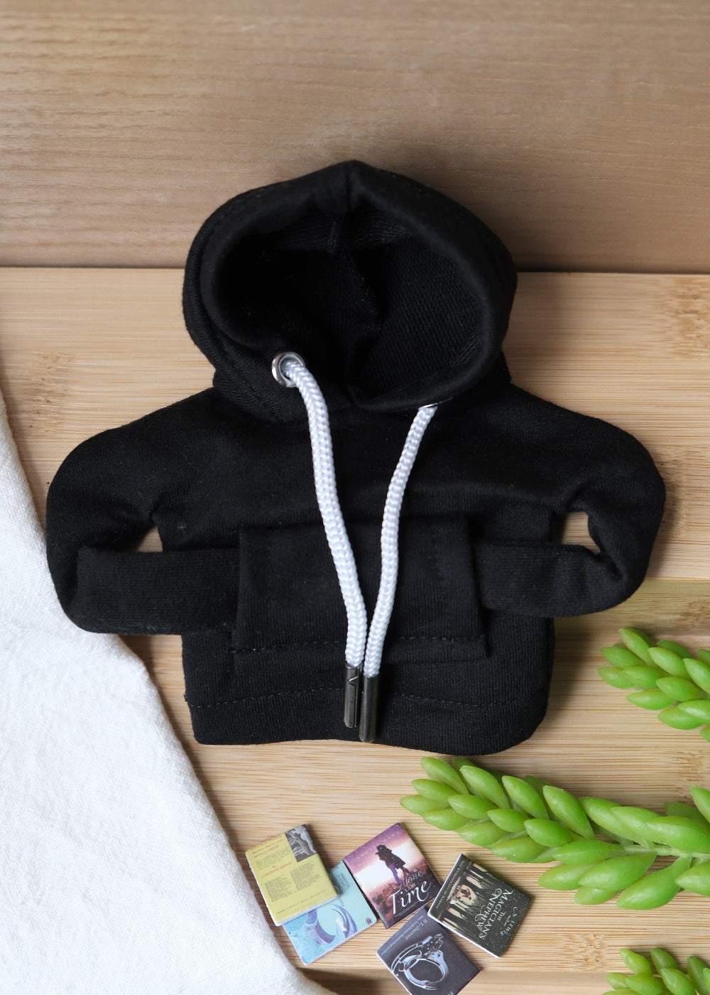 A deformable toy resembling a student wearing a hoodie, beanie, sunglasses, and carrying a backpack with miniature books.