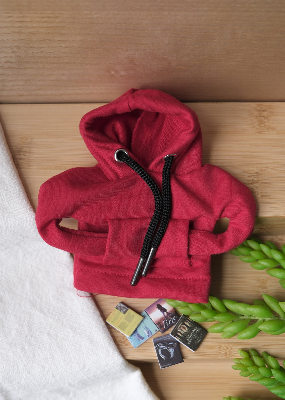 A deformable toy resembling a student wearing a hoodie, beanie, sunglasses, and carrying a backpack with miniature books.