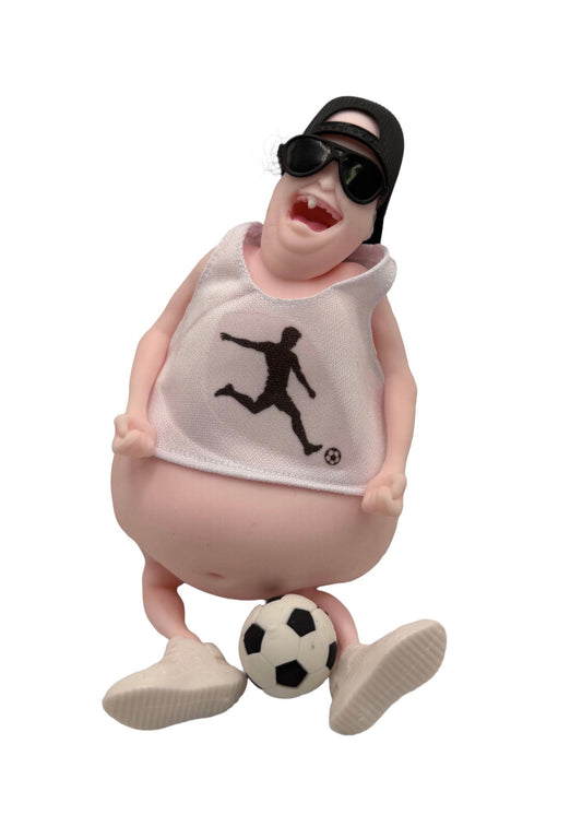 A collectible figurine of a cartoonish, overweight character wearing a white tank top with a black soccer player logo, black sunglasses, and a black cap, balancing on a soccer ball against a white background.