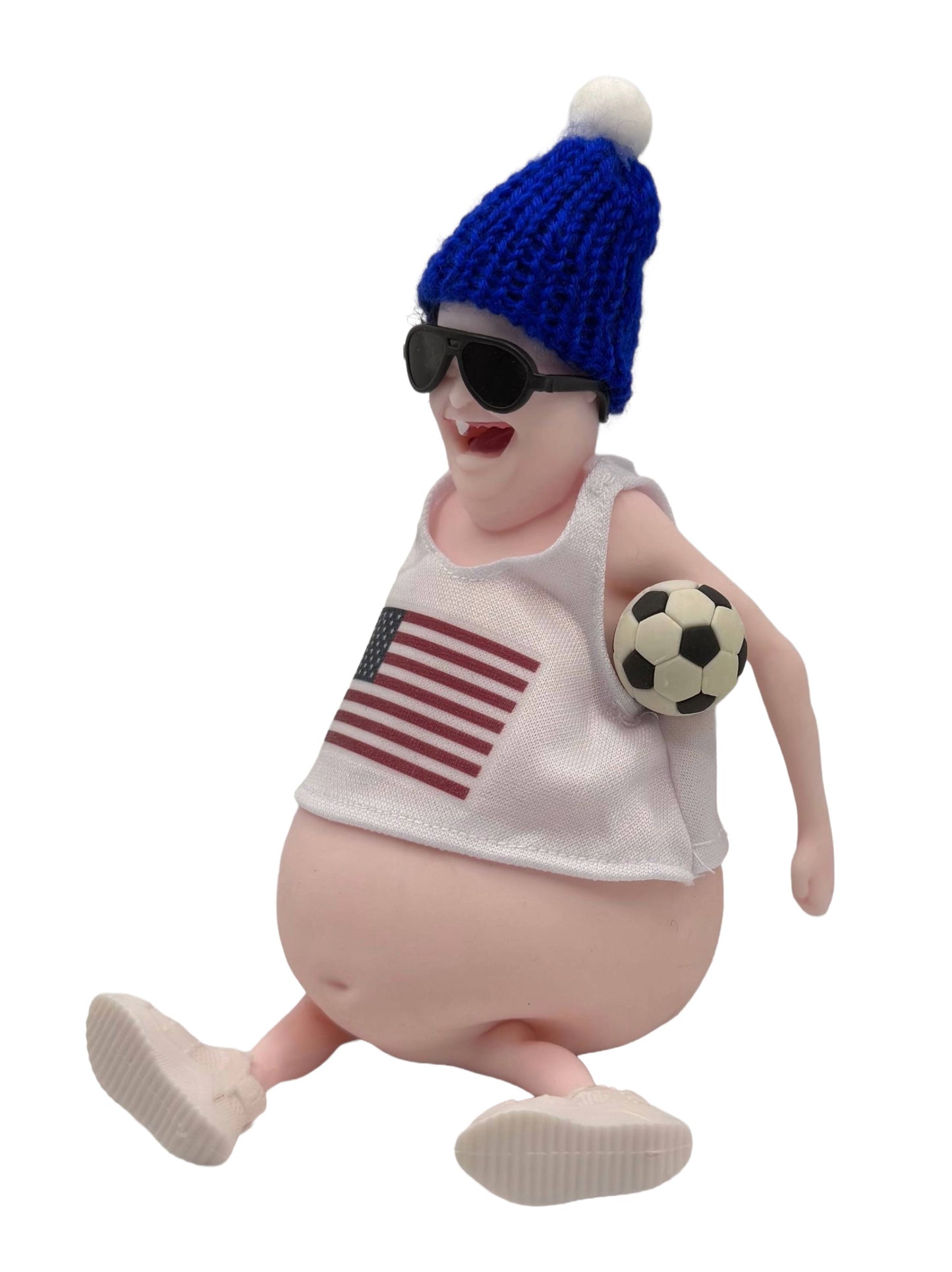 Toy wearing a blue knit hat, sunglasses, and a tank top with an American flag, holding a soccer ball.