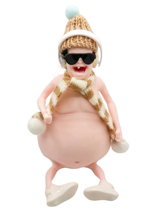 A novelty collectible figurine of a pregnant woman wearing a beige knit beanie with a light blue pom-pom, black sunglasses, and a matching striped knit scarf, set against a plain white background.